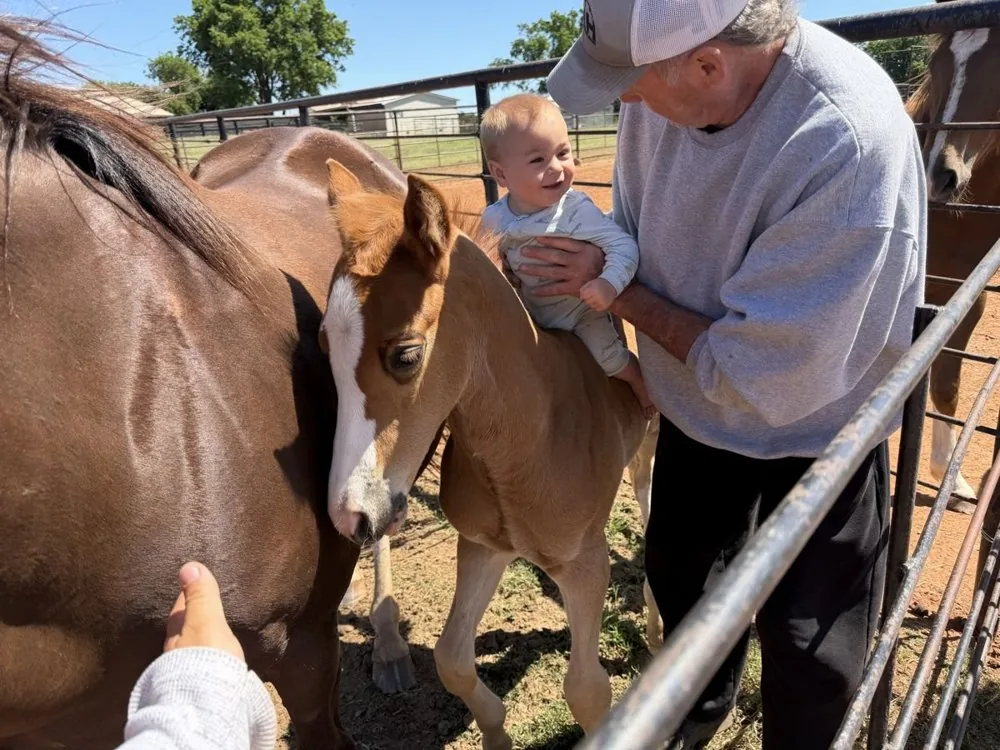 Lenn with a grandchild and a new foal